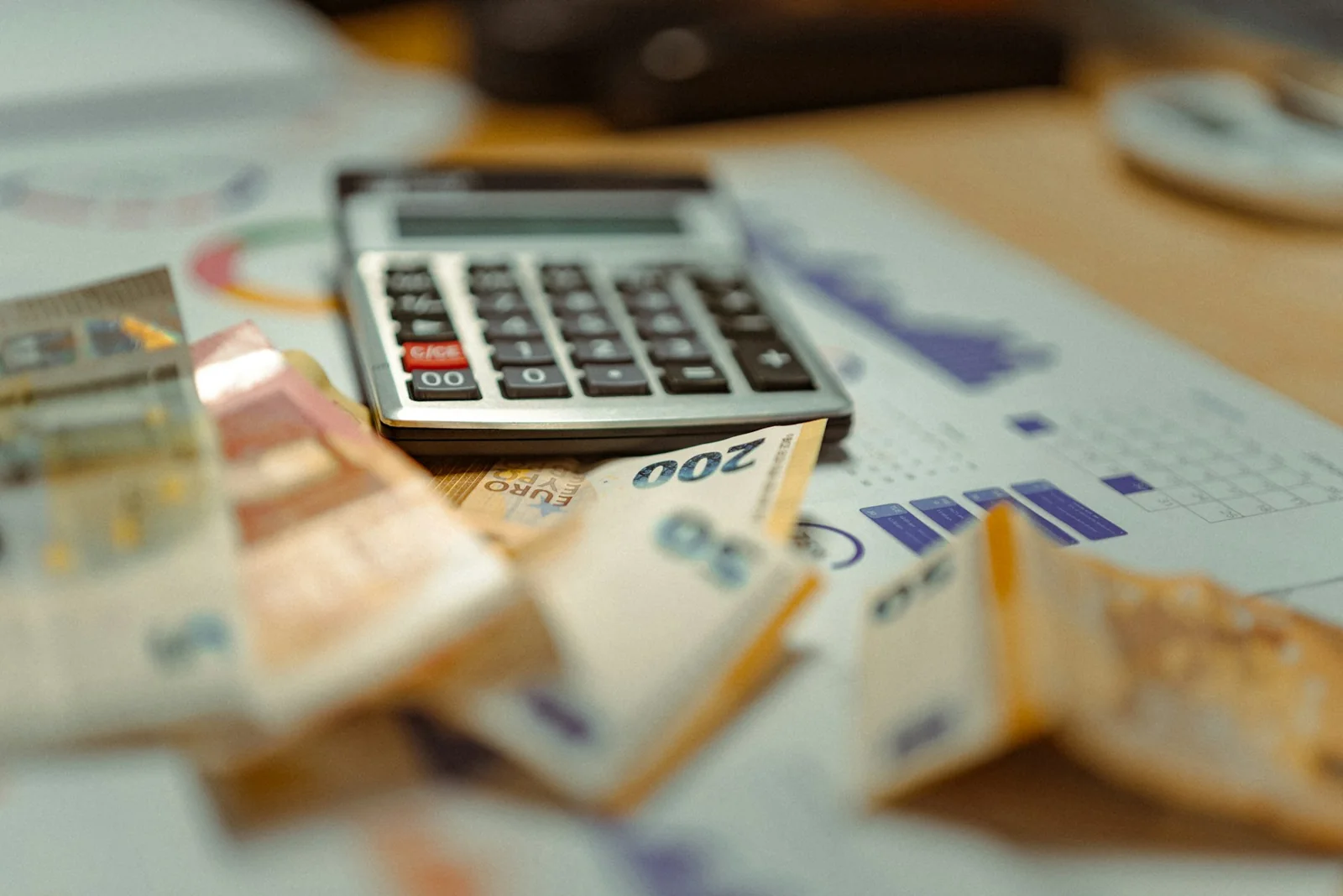 Een rekenmachine, bankbiljetten en papieren om een budget en reserve te plannen.