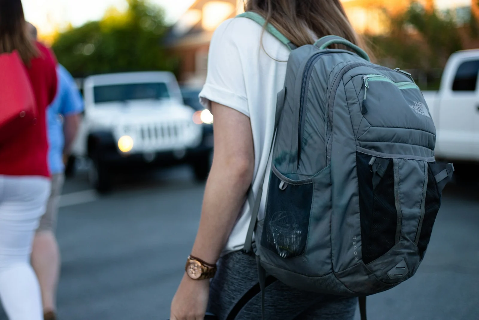 Zaino grigio indossato in strada, con spallacci e tasche visibili