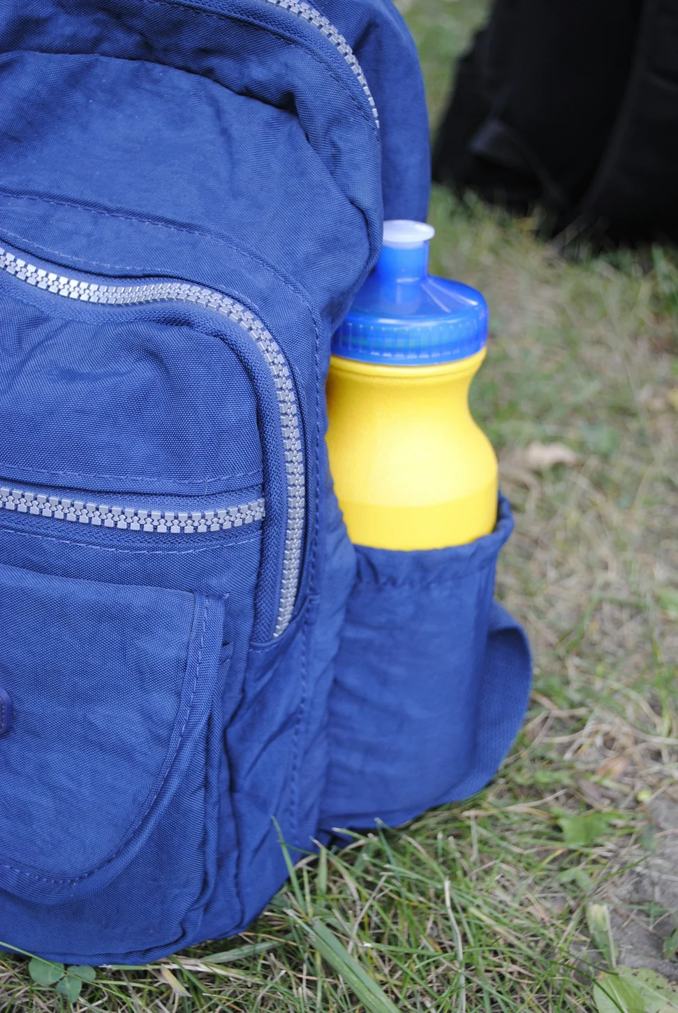 Yellow water bottle in a blue backpack’s side pocket
