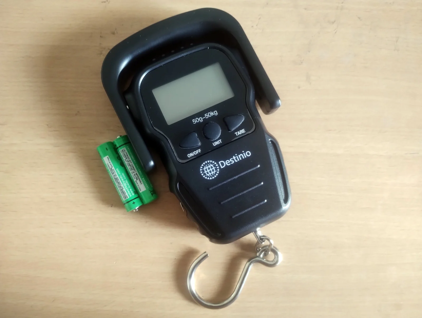 Bilancia digitale per bagagli con gancio e batterie su un tavolo